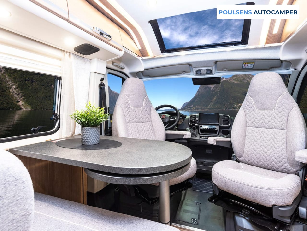 Salon intérieur du camping-car urbain Carthago 640 LE CHARMING GT 2023 avec banquettes et moquette amovible