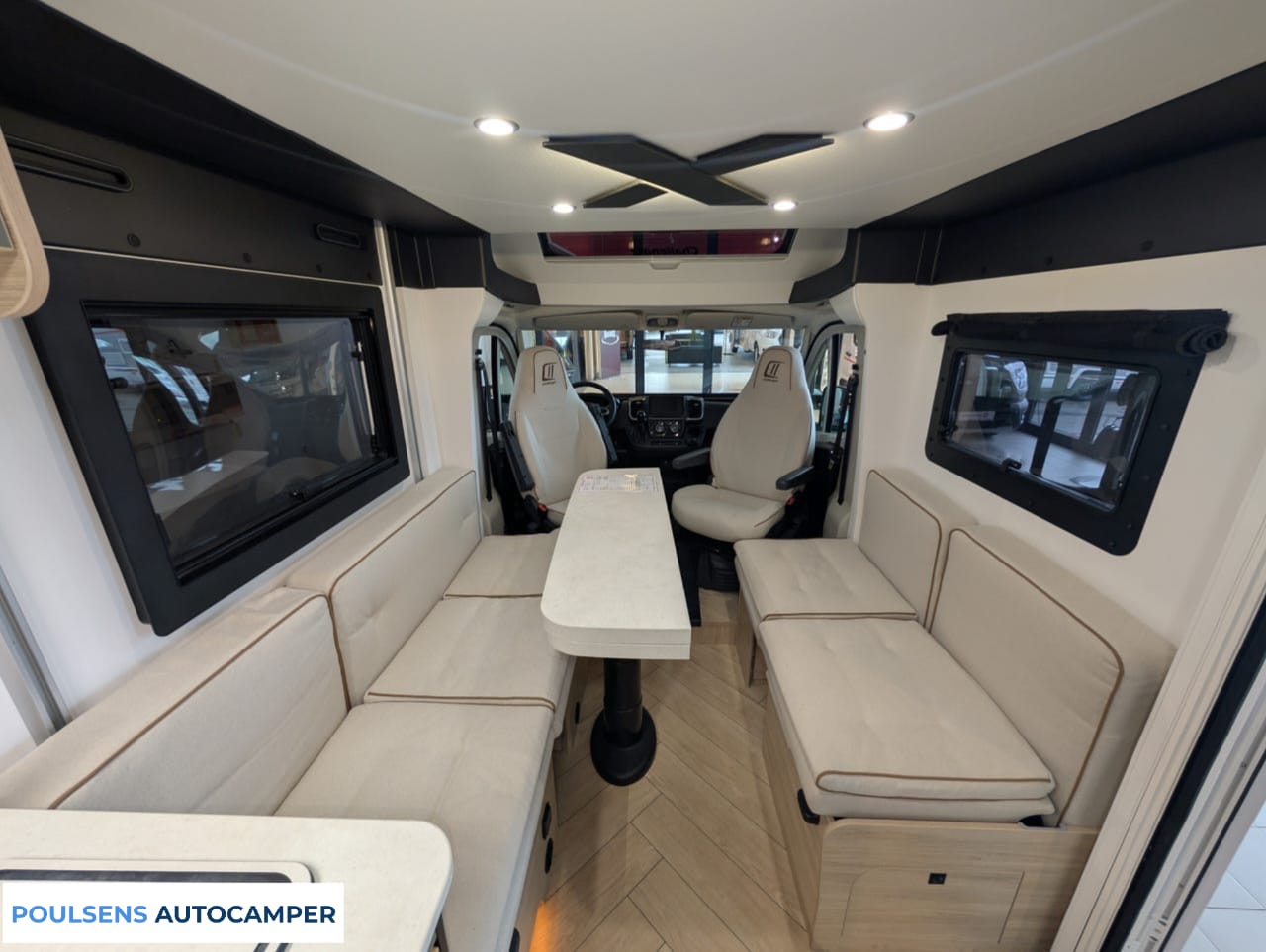 Salon intérieur du camping-car compact Challenger X150 2025 avec banquettes confortables et table centrale