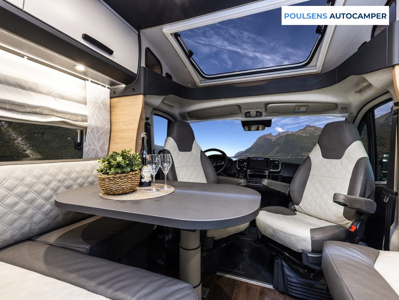Salon intérieur du camping-car semi-intégré Knaus LIVE TI 700 MEG Platinum Selection 2026 avec banquettes et table télescopique