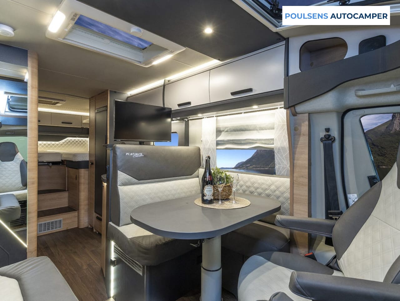 Salon intérieur du camping-car semi-intégré Knaus LIVE TI 700 MEG Platinum Selection 2026 avec banquettes et table télescopique